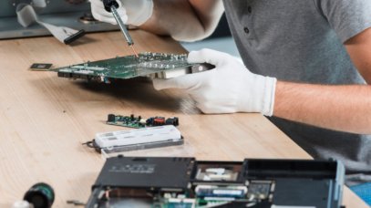 male-technician-repairing-computer-motherboard-wooden-desk